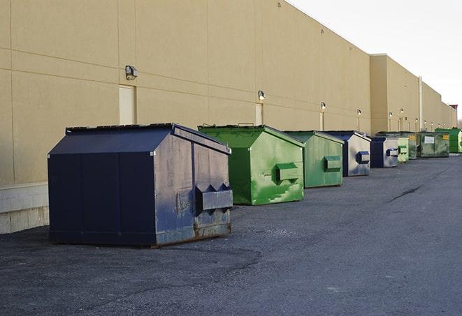 a forklift lifts a full dumpster from a work area in Bermuda Dunes